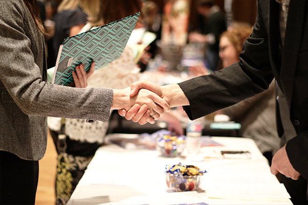 Two people shaking hands at a career fair