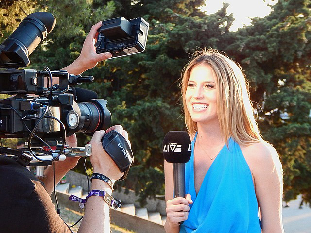 Reporter being filmed while holding microphone