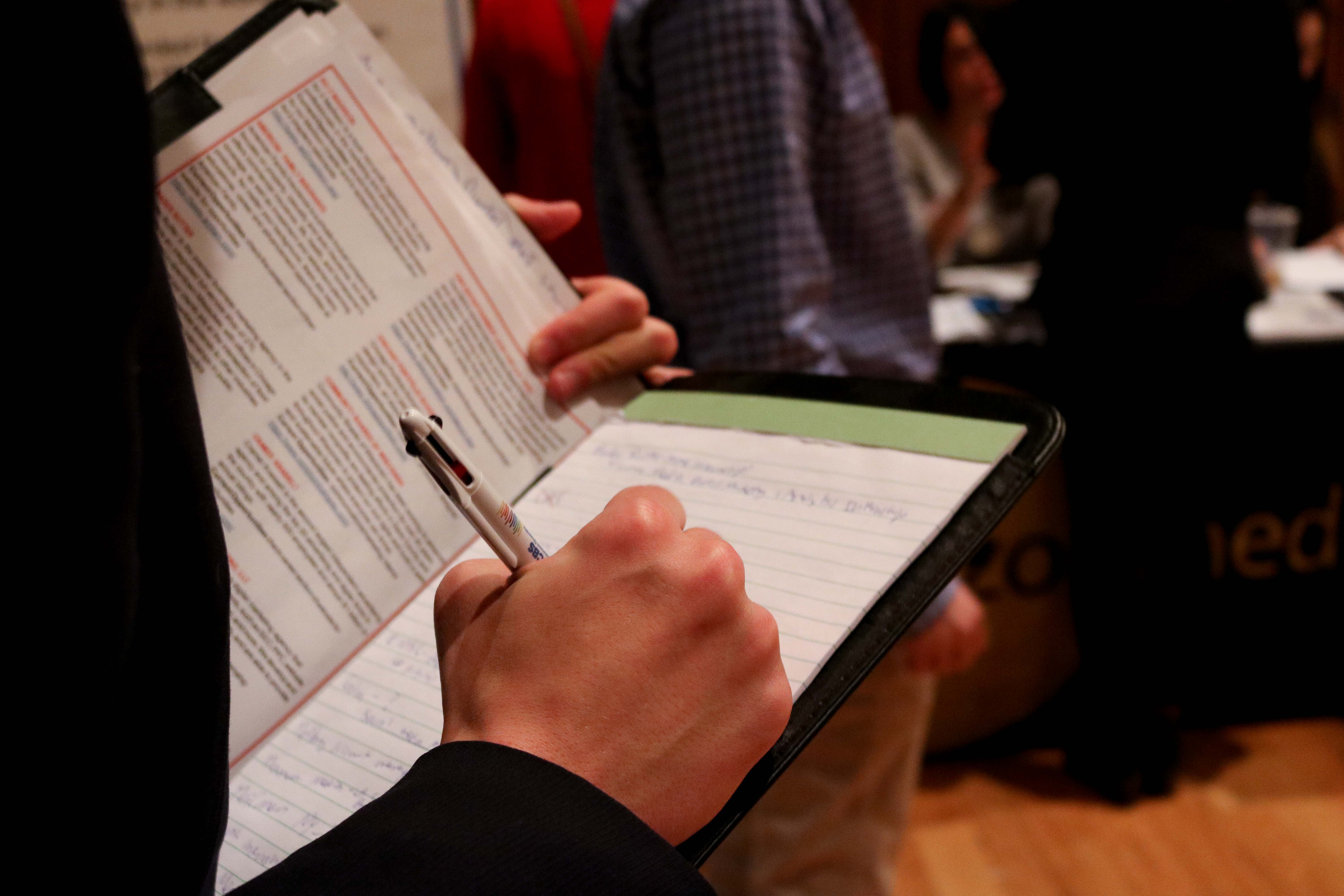A student taking notes at a career fair
