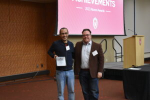 Carlos Dávalos poses with his Teaching Excellence Award and Professor Mike Wagner
