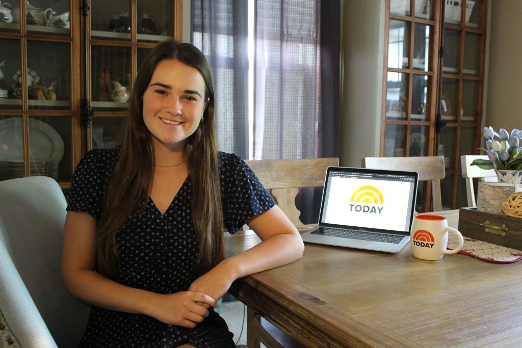 SJMC student Gracie Lund seated next to a laptop and coffee mug, both displaying the TODAY Show logo.