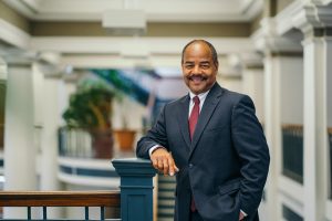 A photo fo Eric Wilcots in a blue suit and red tie