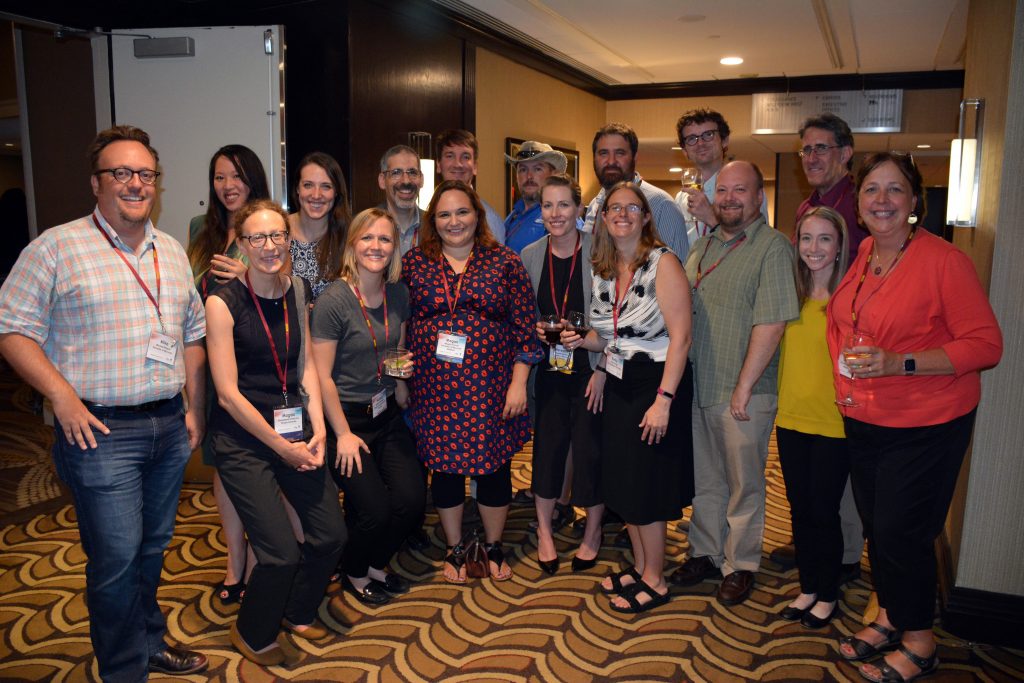 A group of people standing together and smiling for the camera.