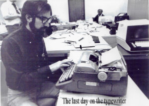 A black and white photo of Phil Haslanger typing on a typewriter.