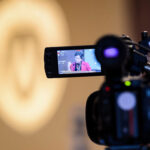 An image of UW-Madison Chancellor Rebecca Blanks is displayed on a video camera as she speaks.