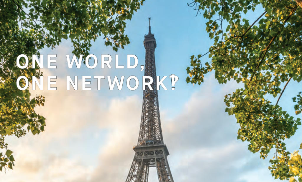 The top of the Eiffel Tower with the text 'One World, One Network‽'