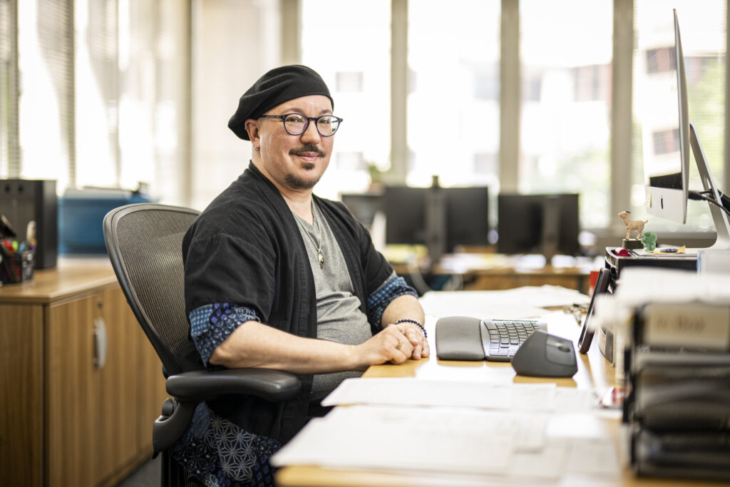 Rowan Calyx seated at his desk in the SJMC main office