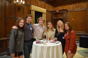 Group of six Curb students stand around a round table smiling for the camera at the Dec. 13 launch party at Memorial Union. 