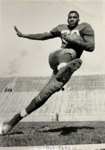 Bob Teague poses on a football field