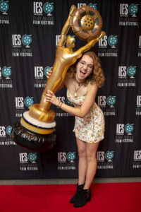 Samantha Stidham poses with an inflatable awards trophy