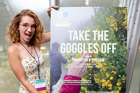 Sami Stidham poses with the poster for her film "Take the Goggles Off."