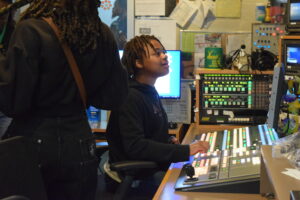 A student plays with a sound board while on a tour of PBS Wisconsin's studios.