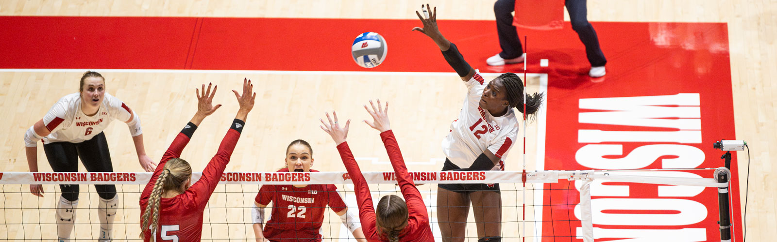 A Badger volleyball player hits the volleyball